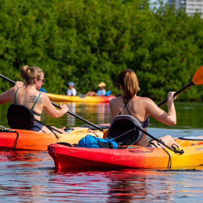 a group of people riding on the back of a boat in the water