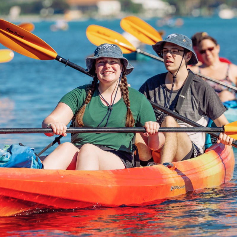 a group of people rowing a boat in the water