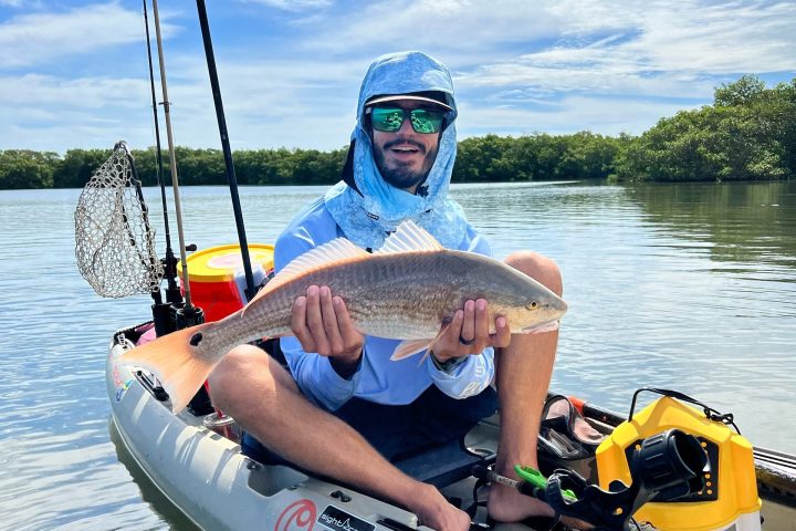 a man riding on the back of a boat in a body of water