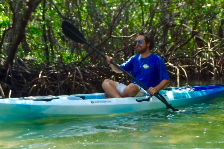 a man riding on the back of a boat in the water