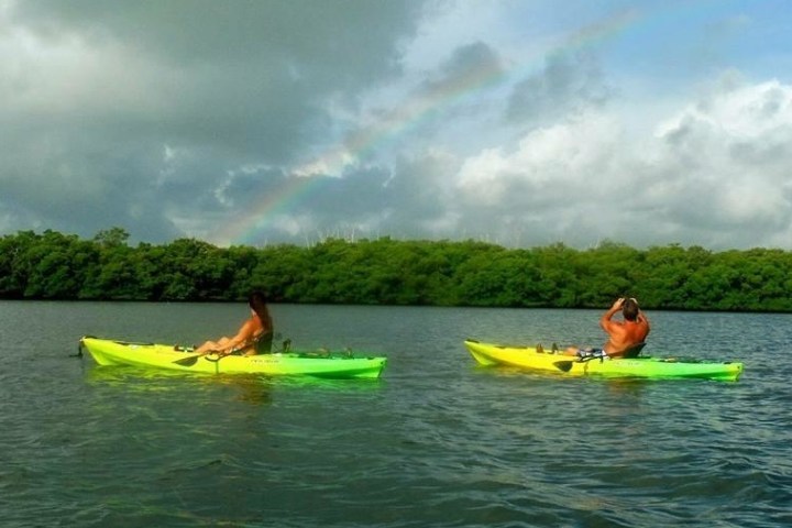 a man riding a green boat on a body of water