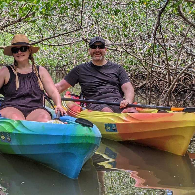 a person riding on the back of a boat next to a river